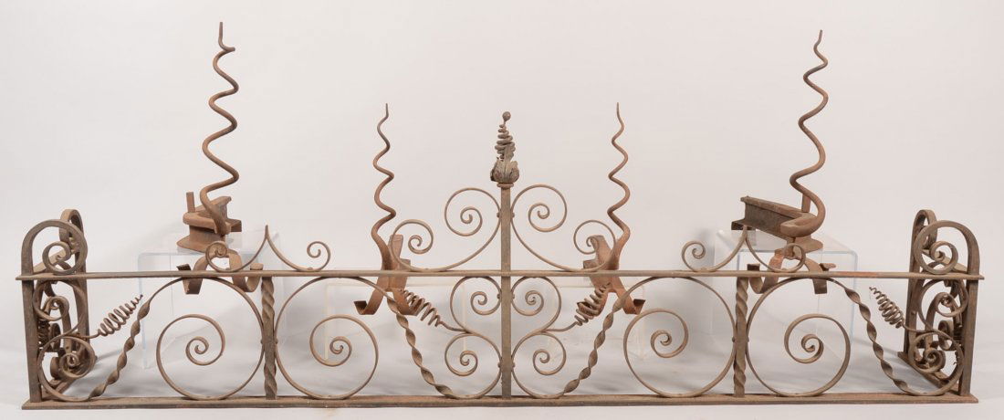 Five Piece Group of Wrought Iron Hearth Equipment.: Five Piece Group of Wrought Iron Hearth Equipment. Early twentieth century floor fender and two pair of andirons. Fender has many "C" scrolls and spiraled finials. 20 1/4"h. X 66"w. X 12"d. Larger and