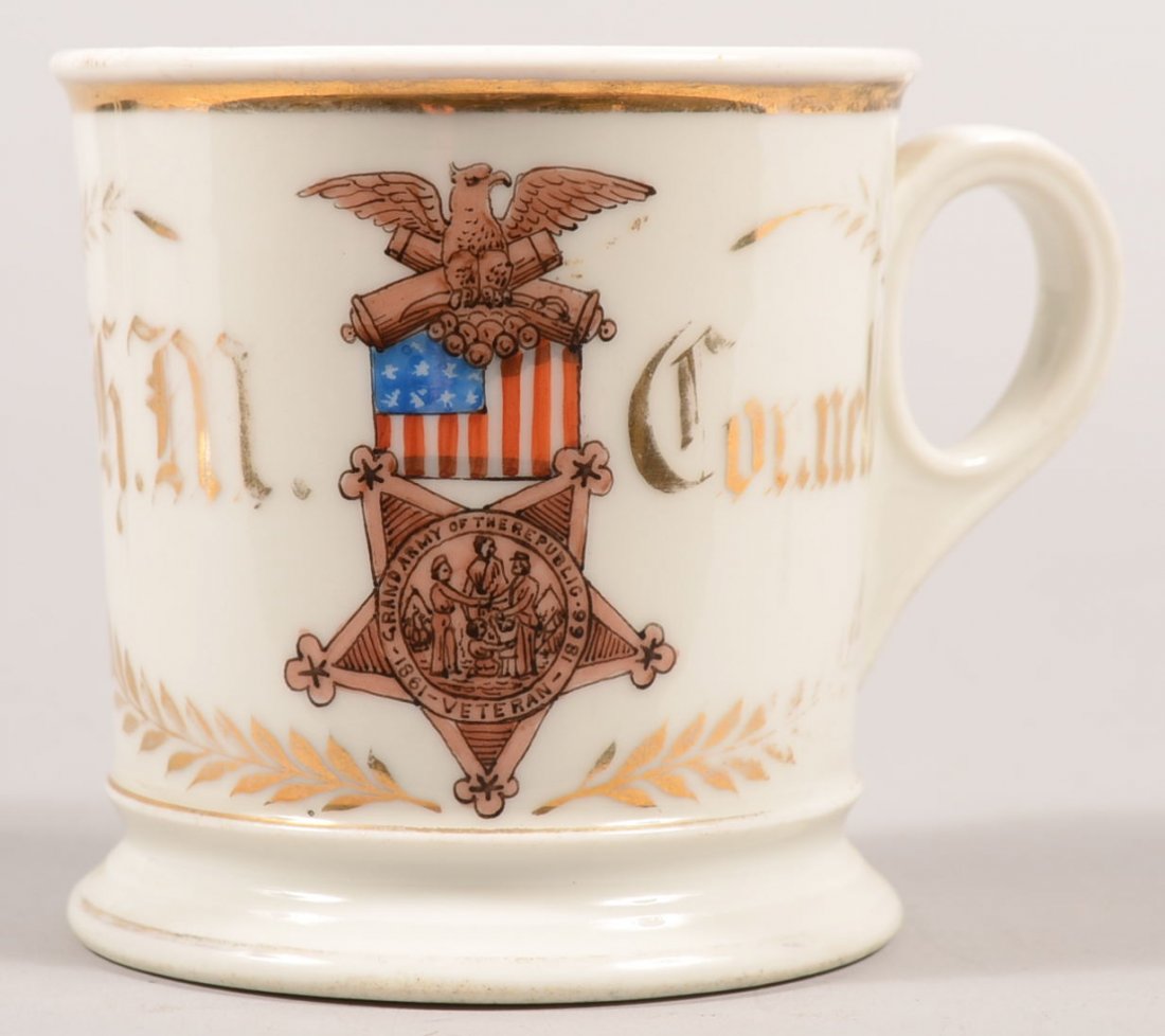 White Ironstone GAR Members Mug. Handpainted in gi: White Ironstone GAR Members Mug. Handpainted in gilt with "H. M. Connelly" and a color members badge along with gilt laurel wreath and rim band. Mug has molded foot and applied ring handle. Made in Fr