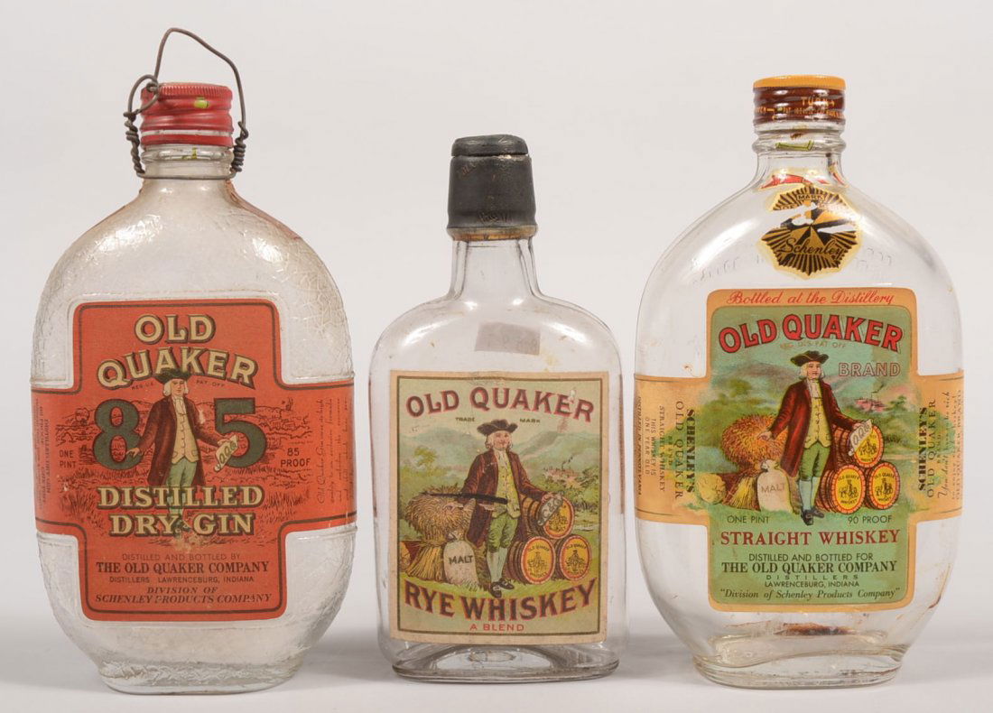 Three Mid Twentieth Century Whiskey Bottles. All O: Three Mid Twentieth Century Whiskey Bottles. All Old Quaker Brand Whiskey. Two oval pint bottles with scew tops, and a half pint bottle with cork and seal. One a red label Dry Gin, one a Straight Whis