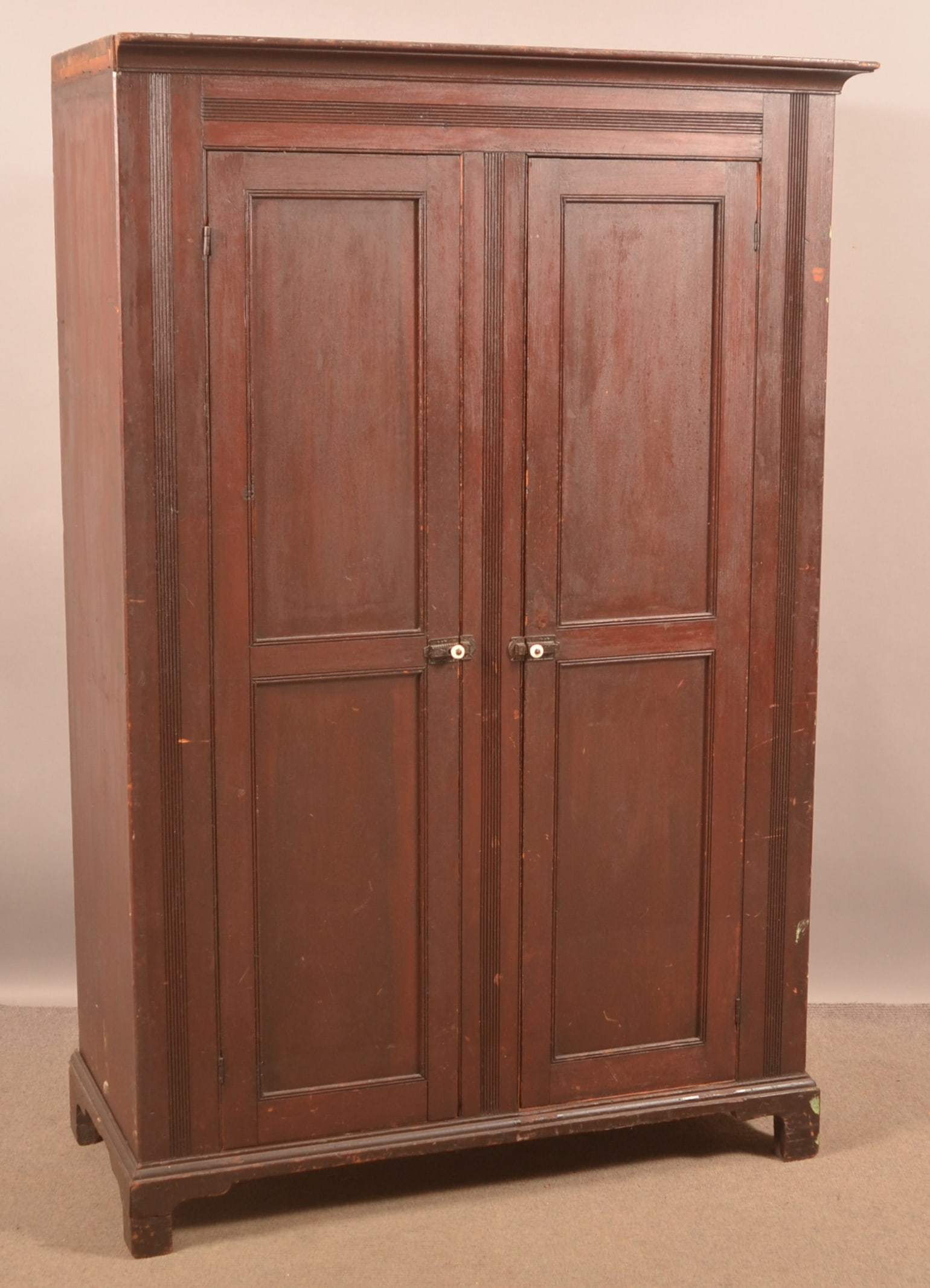 Pennsylvania Country Federal Softwood Wardrobe.: Pennsylvania Country Federal Softwood Wardrobe. Circa 1830. Original reddish/brown paint. Cove-molded cornice, two paneled doors flanked by reeded stiles, interior peg racks and molded bracket base. 6