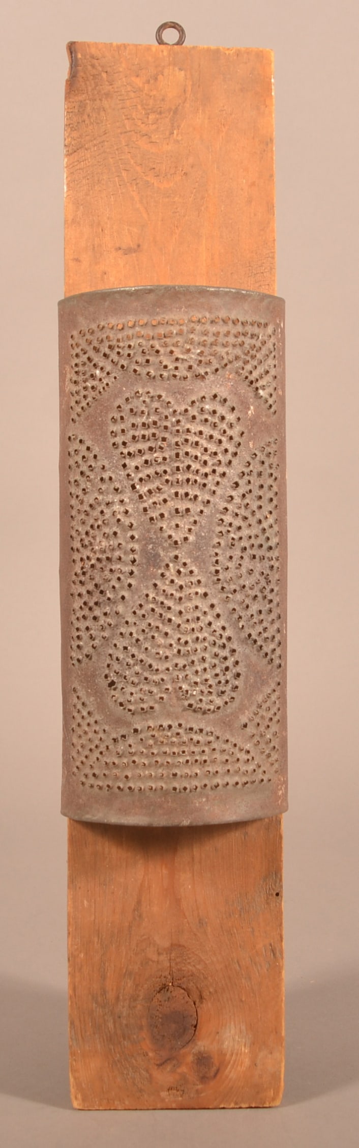 Pennsylvania 19th Century Punched-Tin Grater.: Pennsylvania 19th Century Punched-Tin Grater. Punched-heart motif. Mounted on a pine board. 19-1/2"l.