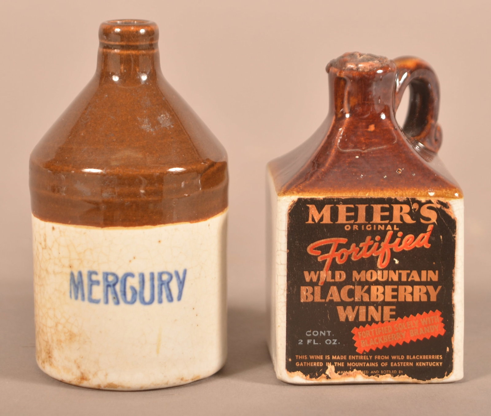 Two Miniature Stoneware Jugs with 2-Tone Glaze.: Two Miniature Stoneware Jugs with 2-Tone Glaze. "Mercury" and "Meier's Blackberry Wine" paper label. Tallest, 3-1/2'h.