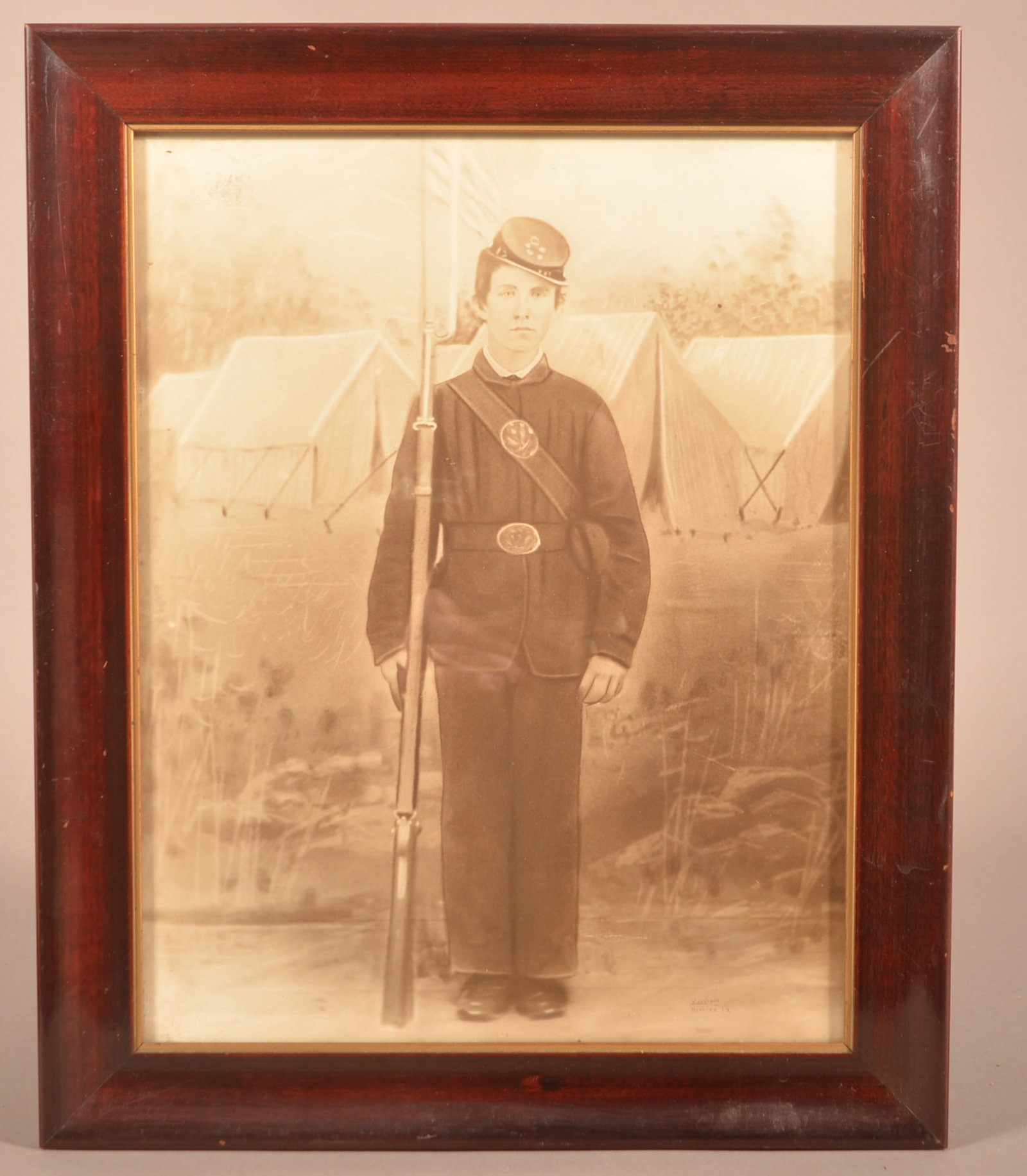 Civil War Soldier Monochrome Image.: Civil War Soldier Monochrome Image. Full-length image of a soldier standing at attention, holding a musket with bayonet at an encampment. Signed lower right "I. Schedor, Reading, PA". Framed, 16-1/2"