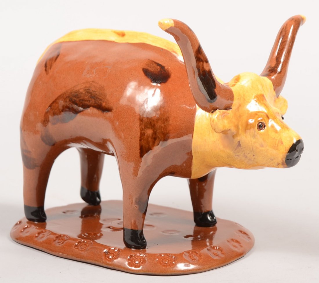 Breininger Pottery Hand Modeled Redware Bull. Three: Breininger Pottery Hand Modeled Redware Bull. Three dimensional bull with long horns on an oblong base impressed with English roses an shell designs. Bull has slip decoration on head and a strip down