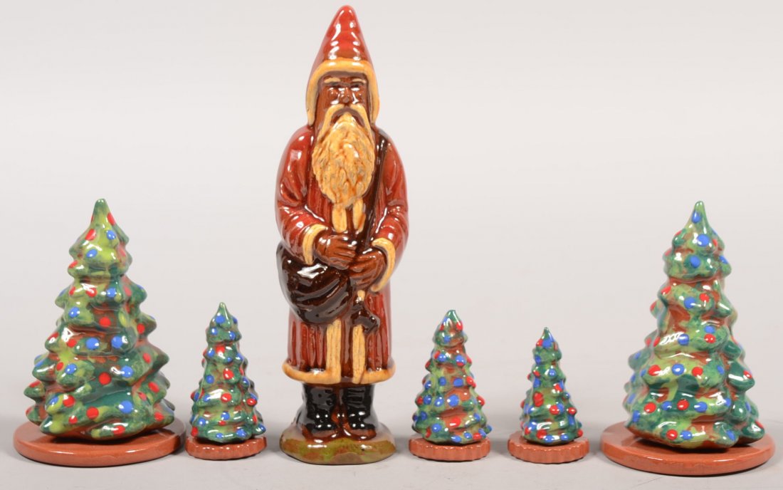 Six Piece Redware Christmas Group. A single molded: Six Piece Redware Christmas Group. A single molded Saint Nicholas in red robe and hat marked on bottom: "Breininger Pottery, 2007." 7"h. Along with five small Christmas trees with red and blue "lights