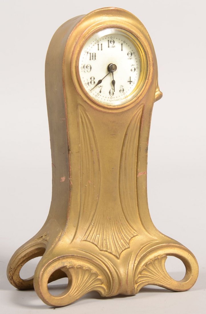 An Ansonia Cast Metal Standing Table Clock. Possib: An Ansonia Cast Metal Standing Table Clock. Possibly an all copper case cast in an Art Nouveau style. White porcelain dial with black Arabic numerals. Case has been over-painted with gold. 7 3/4"h.