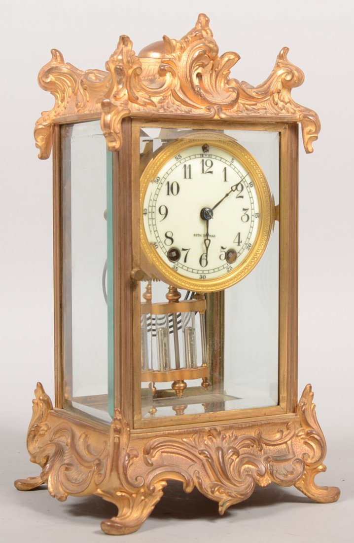 Seth Thomas Gilt Brass Carriage Case Clock. Very d: Seth Thomas Gilt Brass Carriage Case Clock. Very decorative gilt cast brass case with four beveled glass panels. Front and rear doors. Steel slug glass and brass pendulum, porcelain dial with Arabic n