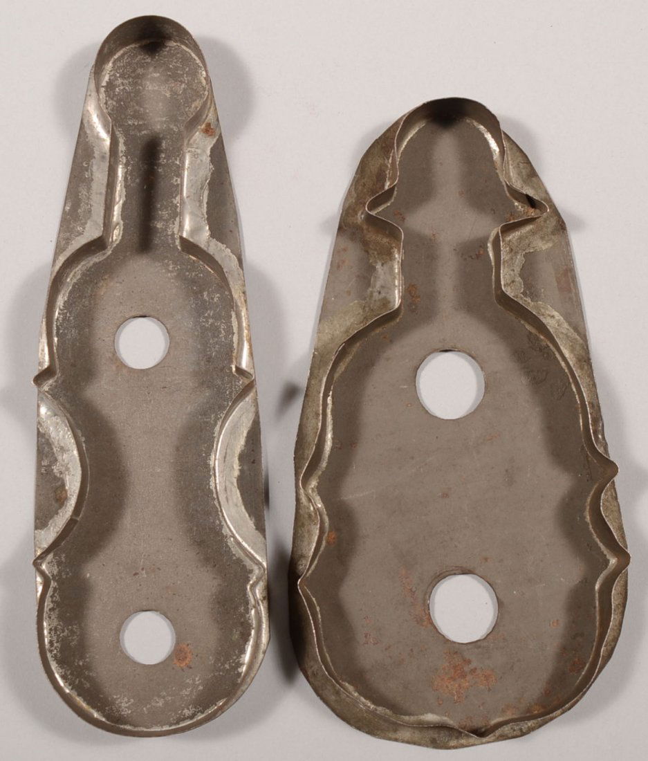 Two Larger Stringed Instrument Tin Cutters. Repres: Two Larger Stringed Instrument Tin Cutters. Representing violins, or bass fiddle. Both backing plates have two vent holes. 7 5/8"l. and 6 3/4"l.