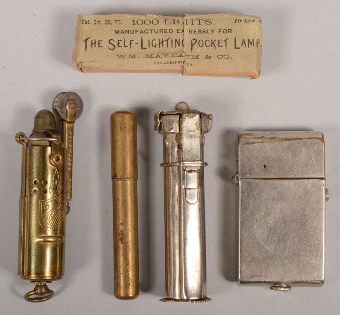 Three Cigar / Cigarette Lighter Devices. A retract: Three Cigar / Cigarette Lighter Devices. A retracting brass lighter marked: "Bowers Mfg. Co., Kalamazoo. MI."3"l. A plated cylindrical lighter patent marked: "Oct. 30, '77" on bottom, 2 7/8"l., with a