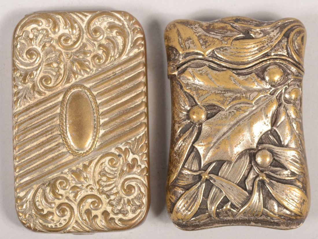 Two Plated Brass Match Safes. One has a tablet ope: Two Plated Brass Match Safes. One has a tablet opening with embossed designs on cover and striker on inside cover, 2 1/2"l. X 1 1/2"w. Along with an embossed holly and laurel leaf design with rippled 