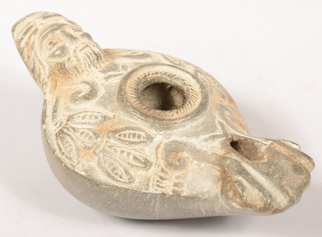 Byzantine or Early Islamic Type Carved Soapstone O: Byzantine or Early Islamic Type Carved Soapstone Oil Lamp. Top features a man with ears of corn or pods of peas decoration. Serrated discus around pouring hole. Single nozzle and a knob handle with a 
