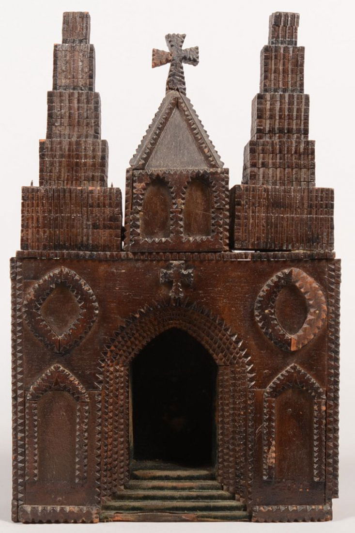 A Tramp Art Style Chip Carved Statuette Shrine. Da: A Tramp Art Style Chip Carved Statuette Shrine. Dark stained case appears as a cathedral façade with a central hip roof steeple having a cross finial and flanked by two stacked and graduated towers.