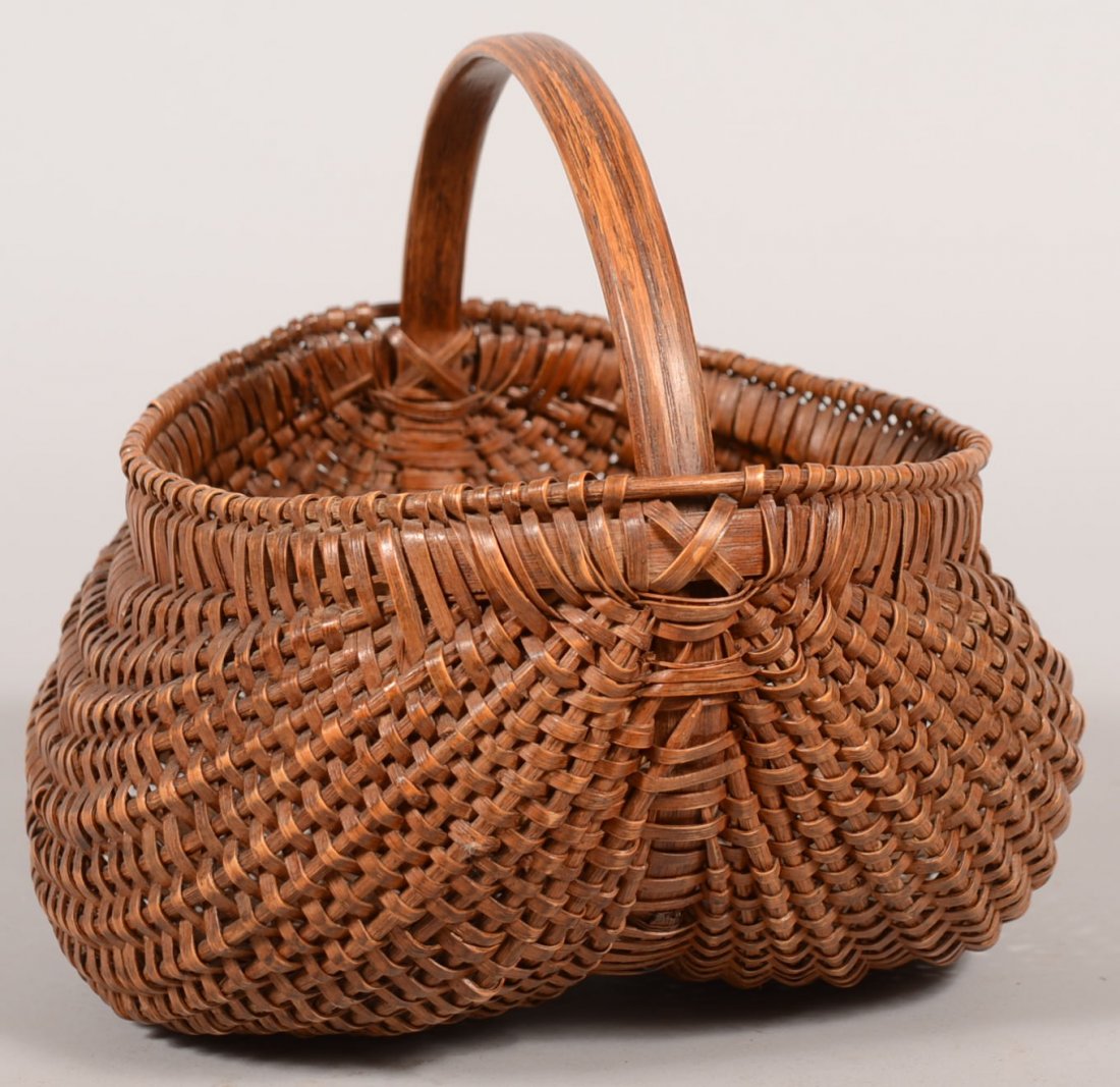 White Oak Buttocks Shaped Gathering Basket. Drawn : White Oak Buttocks Shaped Gathering Basket. Drawn round ribs with a bound strip and beaded rim and carved strip handle. 9"h. X 10"w.