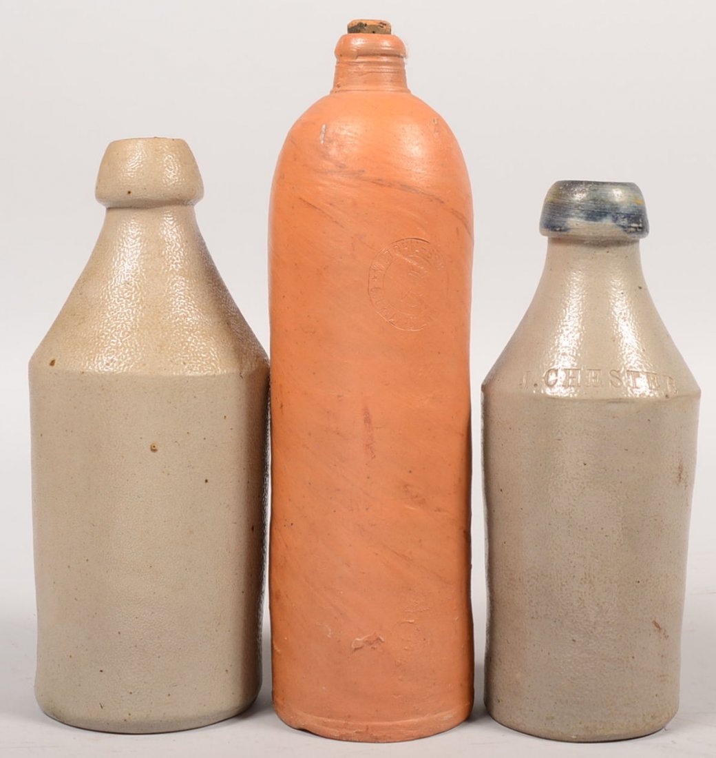 Three Stoneware Bottles. One has cobalt blue aroun: Three Stoneware Bottles. One has cobalt blue around the top and is impressed with "Lemon Beer" on one shoulder rim and "J. Chester" on the opposite. 9 1/8"h. Along with another without markings or col