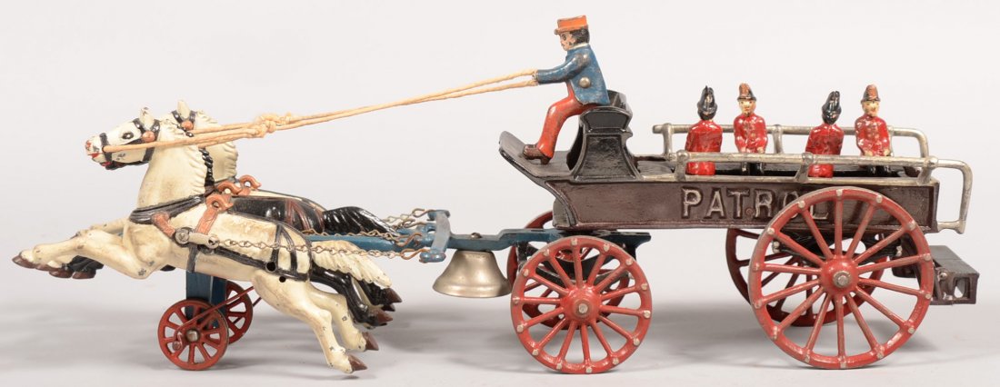Dent Three Horse Cast Iron Patrol Wagon. Black pai: Dent Three Horse Cast Iron Patrol Wagon. Black painted open wagon with red wheels, silver rails, four uniformed firemen and a driver. Pulled by three horses on blue traces with a two red wheel support