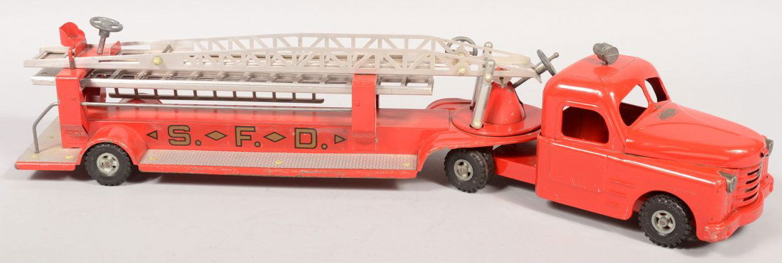 Structo Pressed Steel Hook & Ladder Fire Engine. O: Structo Pressed Steel Hook & Ladder Fire Engine. Overall red paint with silver ladders and gold with black decals. Applied aluminum diamond plate. Fifth wheel seat with steering wheel. Truck has plast