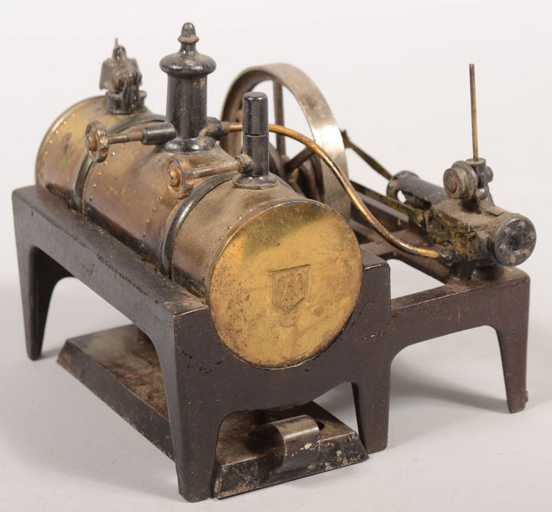 Steam Engine Toy with Wood Box. Banded brass water: Steam Engine Toy with Wood Box. Banded brass water tank on cast iron frame stand with separate triple wick burner, blow-off valves, cast pressure piston and plated flywheel. Contained in a finger join
