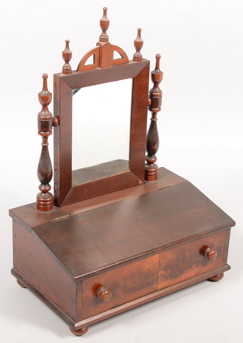 Mahogany Veneer Dressing Mirror and Box. Double kn: Mahogany Veneer Dressing Mirror and Box. Double knob faux drawer with slant lift lid and suppressed ball feet. Two turned posts with urn shaped finials holding a bevel faced mirror frame having an arc