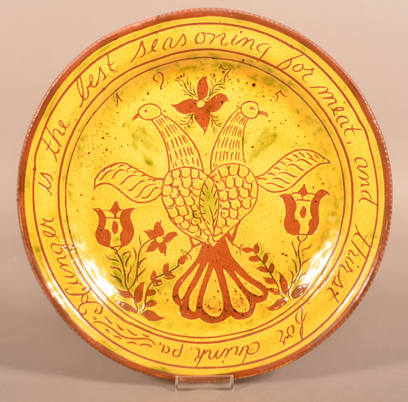 Breininger Redware Sgraffito Charger Dated 1975.: Breininger Redware Sgraffito Charger Dated 1975. With "TM" Taylor Mansion logo. Yellow and green glaze with double Distelfink in center and verse border. 12-3/4" diam.