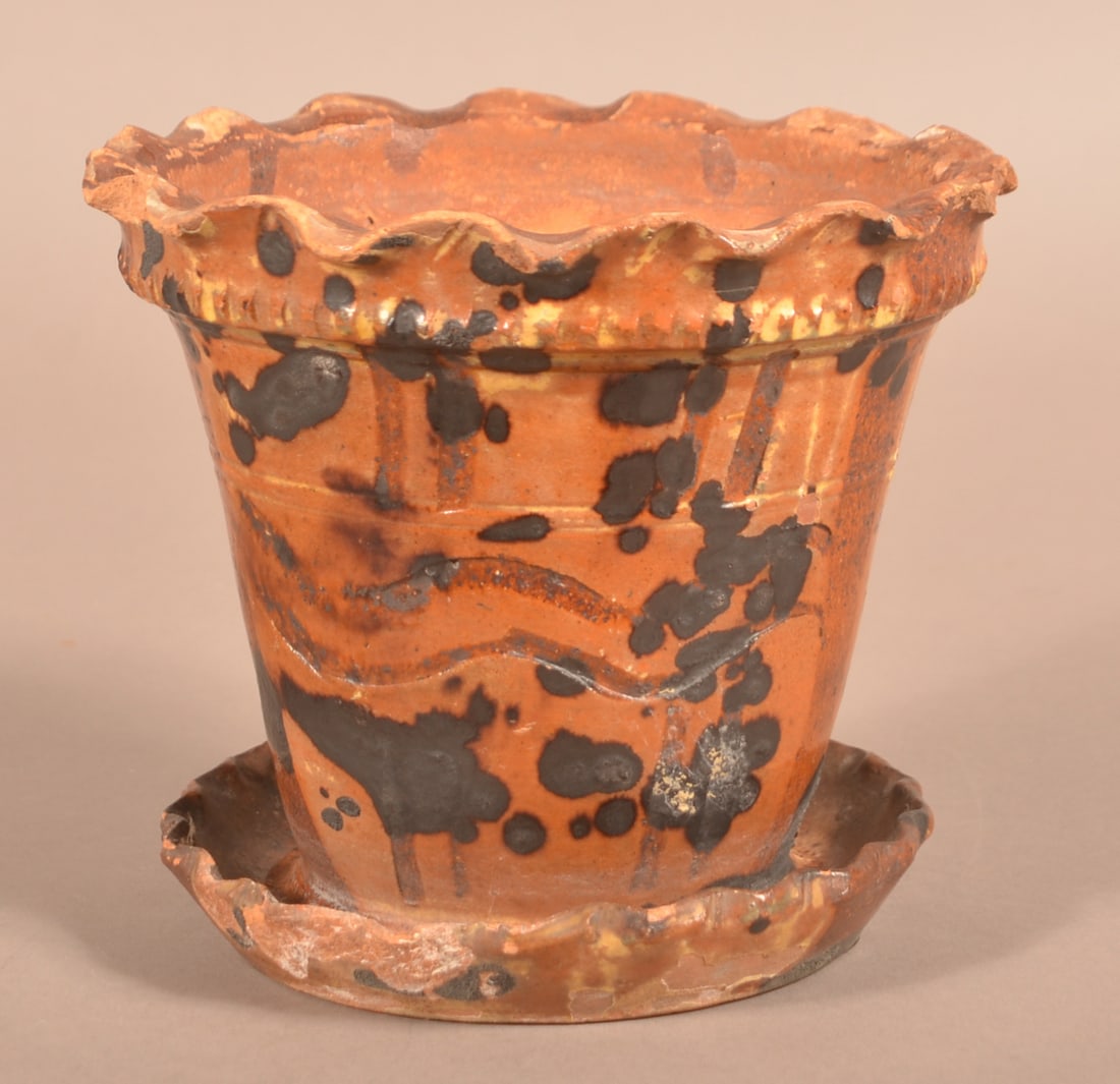 Antique Mottle-Glazed Redware Planter.: Antique Mottle-Glazed Redware Planter. Ruffled rim, above a coggled band, tapered body with pressed decoration attached saucer base with ruffled rim. 6"h.
