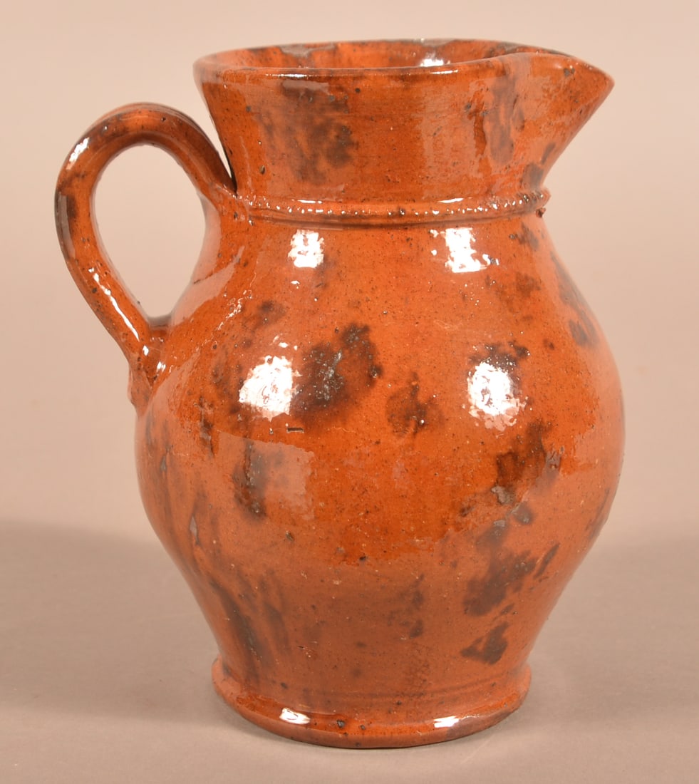 Glazed Redware Pitcher Attrib. to Jacob Medinger.: Glazed Redware Pitcher Attributed to Jacob Medinger. Limerick Township, Montgomery County, PA, circa 1880-1930. Ovoid pitcher with ribbed handle, flared collar, and coggled molding to collar. Decorate
