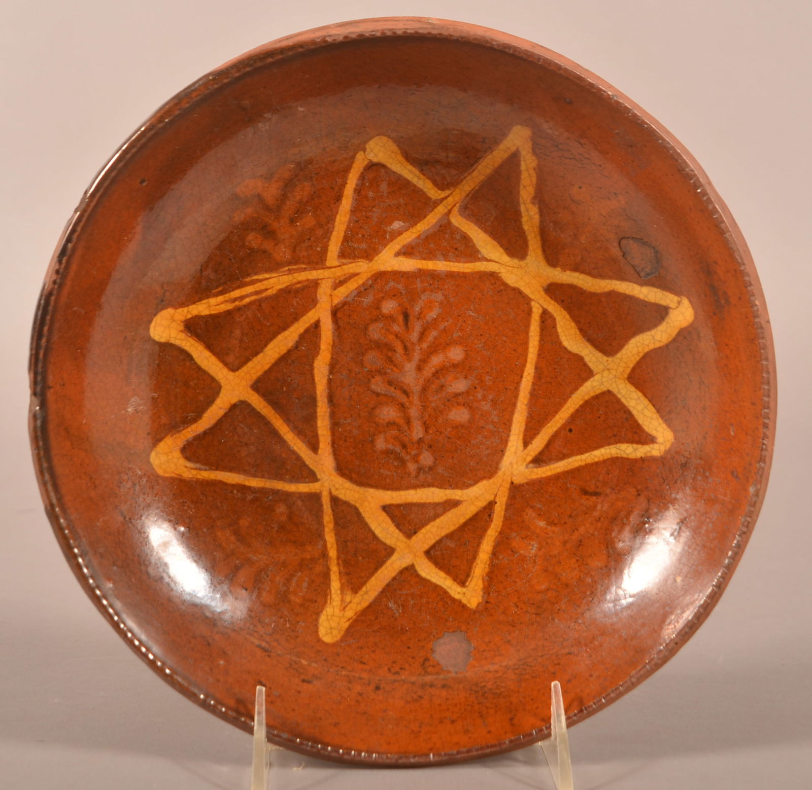 Pennsylvania 19th Century Redware Plate.: Pennsylvania 19th Century Redware Plate. 8-pointed yellow slip star with alternating fern sprig design. Provenance: The late Jan Paden, Duncannon, PA. 9-1/4" diam.