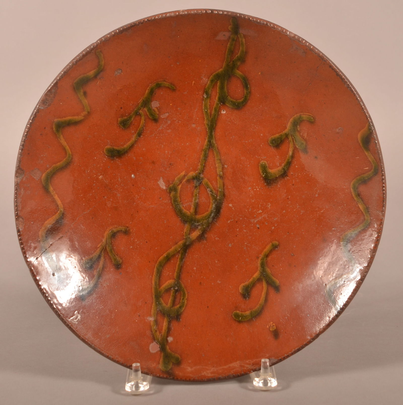 PA Redware Charger with Slip Decoration.: Pennsylvania Redware Charger with Slip Decoration. 19th century. Green and yellow slip decoration and coggle wheel edge. Provenance: The late Jan Paden, Duncannon, PA. 12" diam.