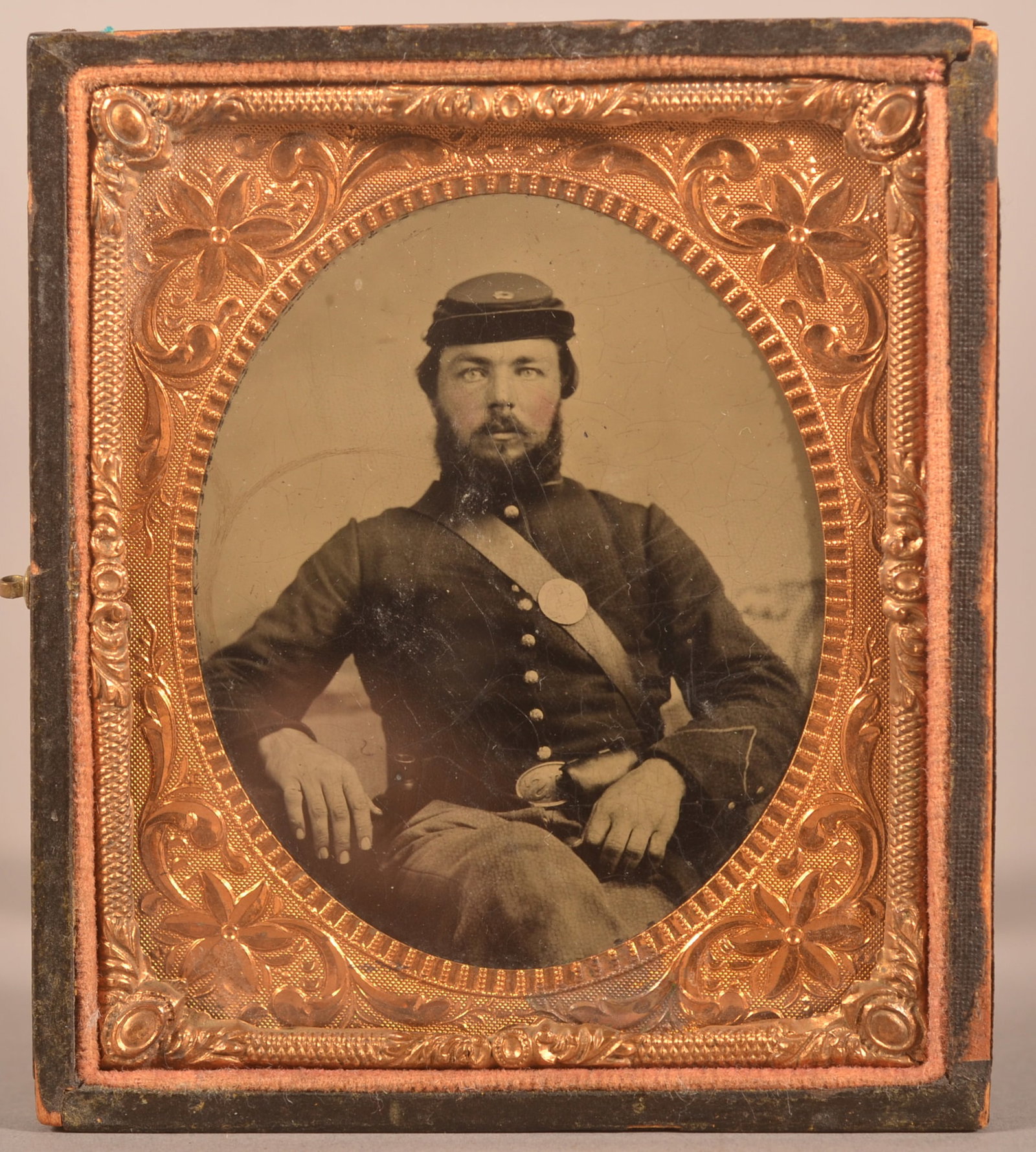 1/6th Cased Tintype of Union Soldier: Clear image of a seated soldier wearing a pattern 1839 belt plate with cartridge box a keppi hat, missing case cover with expected wear.