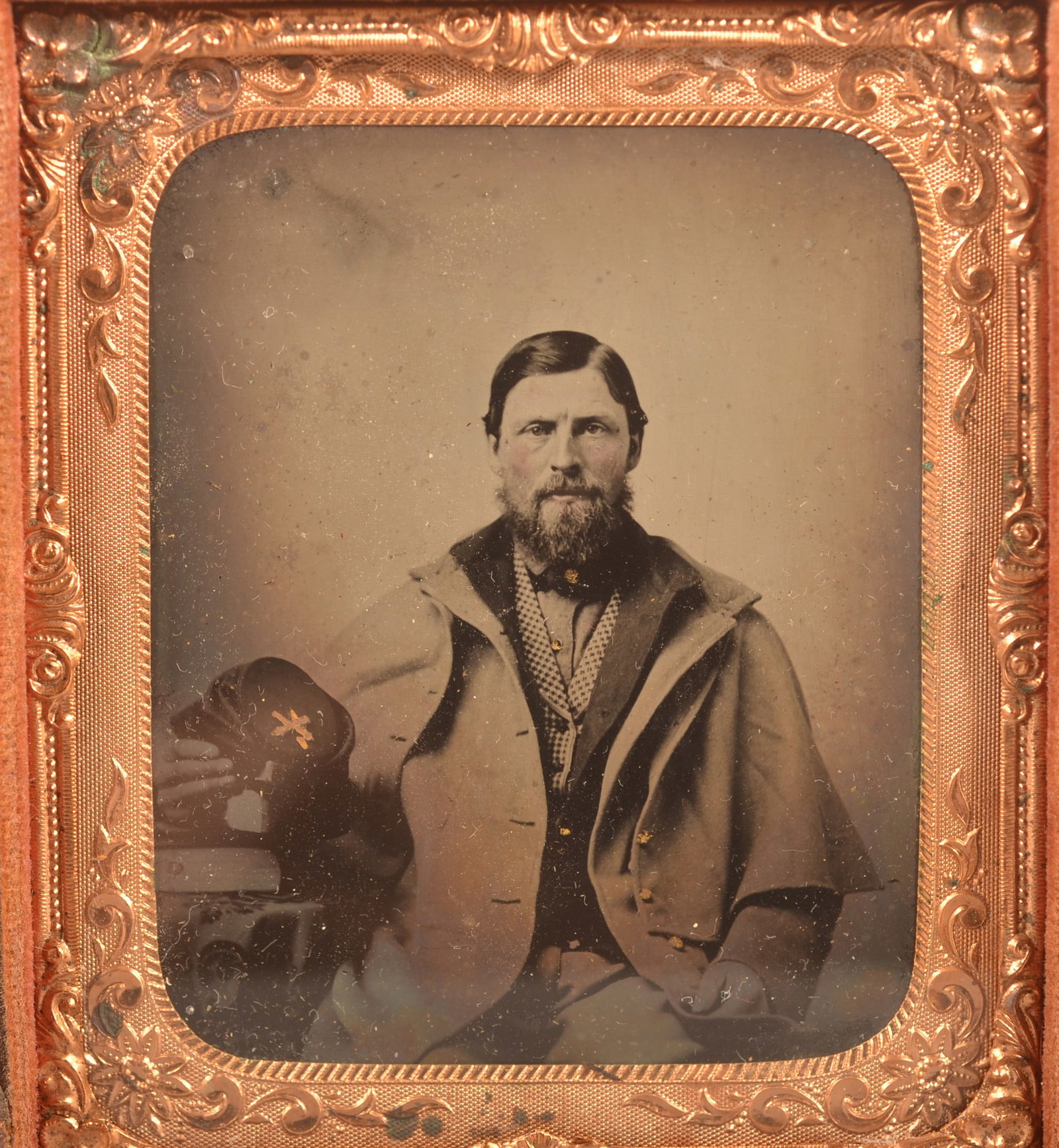 1/6th Cased Tintype of Union Soldier: Seated soldier wearing a Greatcoat while holding his Kepi hat, clear image with expected wear to the case.