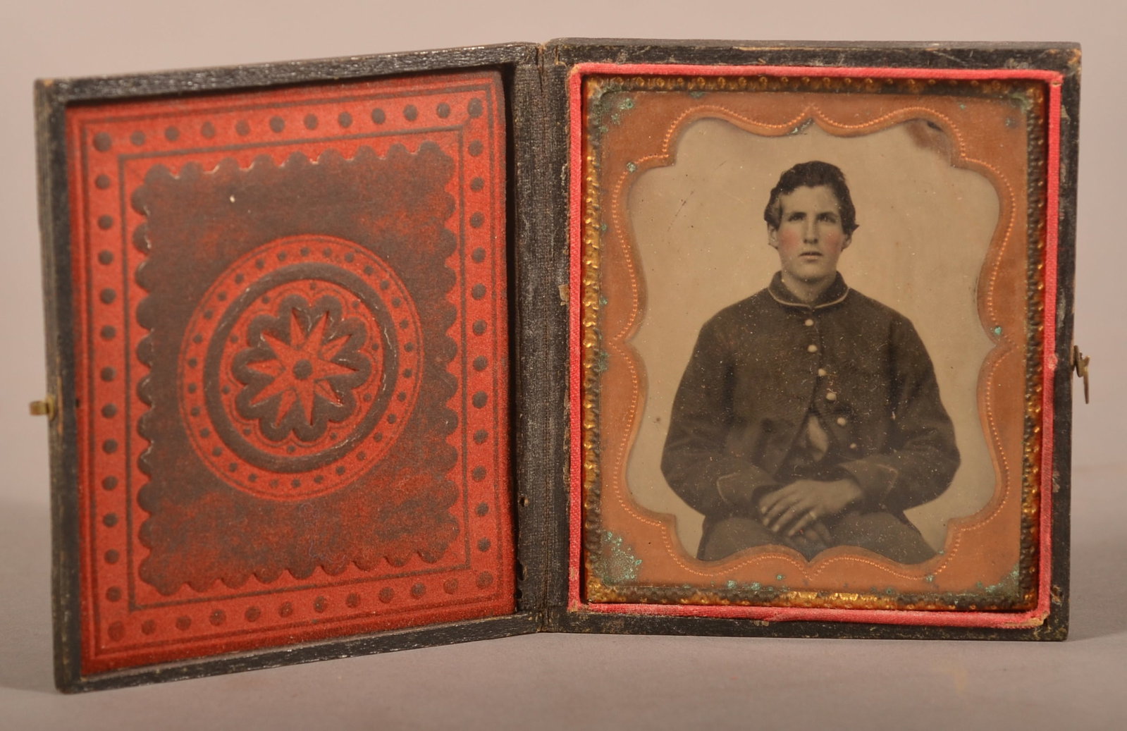 1/6th Cased Tintype of Union Soldier: Clear image of a seated soldier wearing a frock coat, areas of tarnish on the guilt plated matting, expected wear and signs of age.