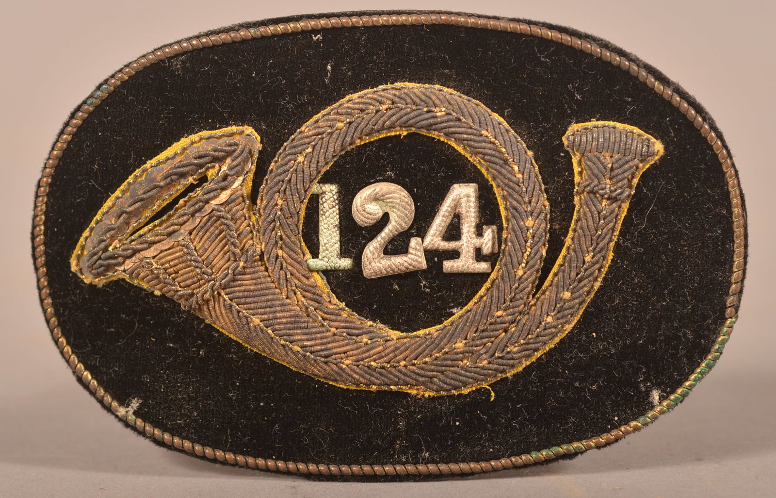 Embroidered Hat Insignia 124th Infantry Regt.: Believed to be 124th Pennsylvania. Embroidered horn insignia with bullion and sequins on a black velvet backing, normal age discoloration and minor color fading, as-found recovered condition.