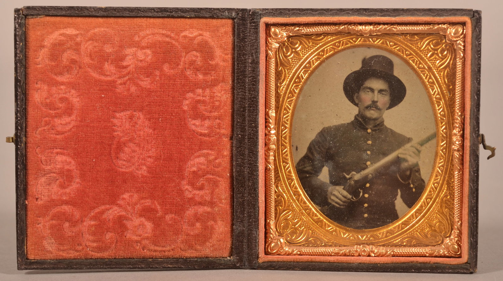 1/6th Cased Tintype of Union Soldier: Clear image of soldier holding a contract musket and wearing a slouch hat, shows areas of minor blistering, expected finish wear and signs of age.