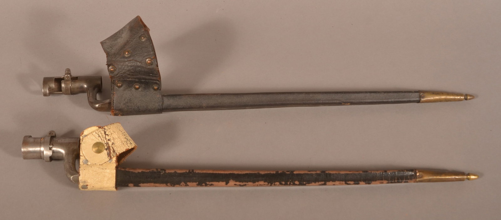 2 mod. 1855 Socket Bayonets: Includes scabbards that have excessive finish flaking, crazing, and wear. One bayonet has a visible U.S. proof mark and the other has an "A.D." proof mark. Overall fair condition.