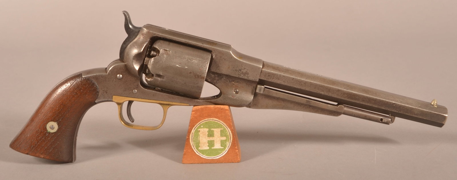 Remington mod. 1858 .44 cal. Percussion Revolver: SN 6526, 8" barrel with 2-line address highlighted in white, brass trigger guard with smooth wooden grip panels, incised carved "SAM BASS" on the underside of the grips, original finish has been remov