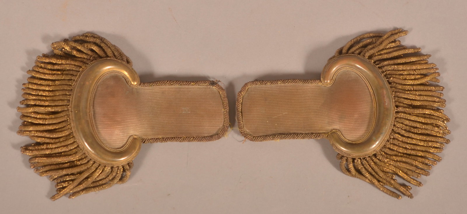 Officer Dress Epaulettes: Bullion and tassel decoration with a faded, untouched and aged patina, underside is hand signed S.G. Cocklla, no visible makers marks, underside fabric has thinned and shows loss around the edges, age