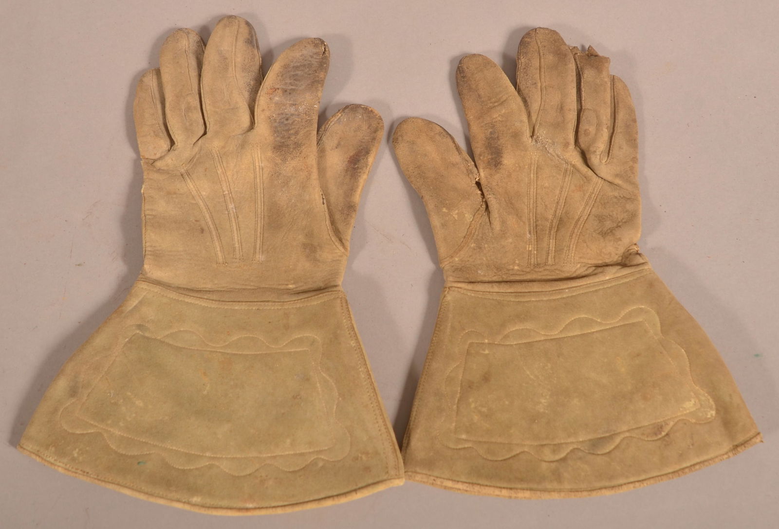 Civil War Cavalry Gauntlet Gloves: Buckskin gloves with a stitched design on the cuffs, stained and aged discolored, loose stitching with separation at the thumbs, previous owner has their initials written on the inside of the cuffs, o