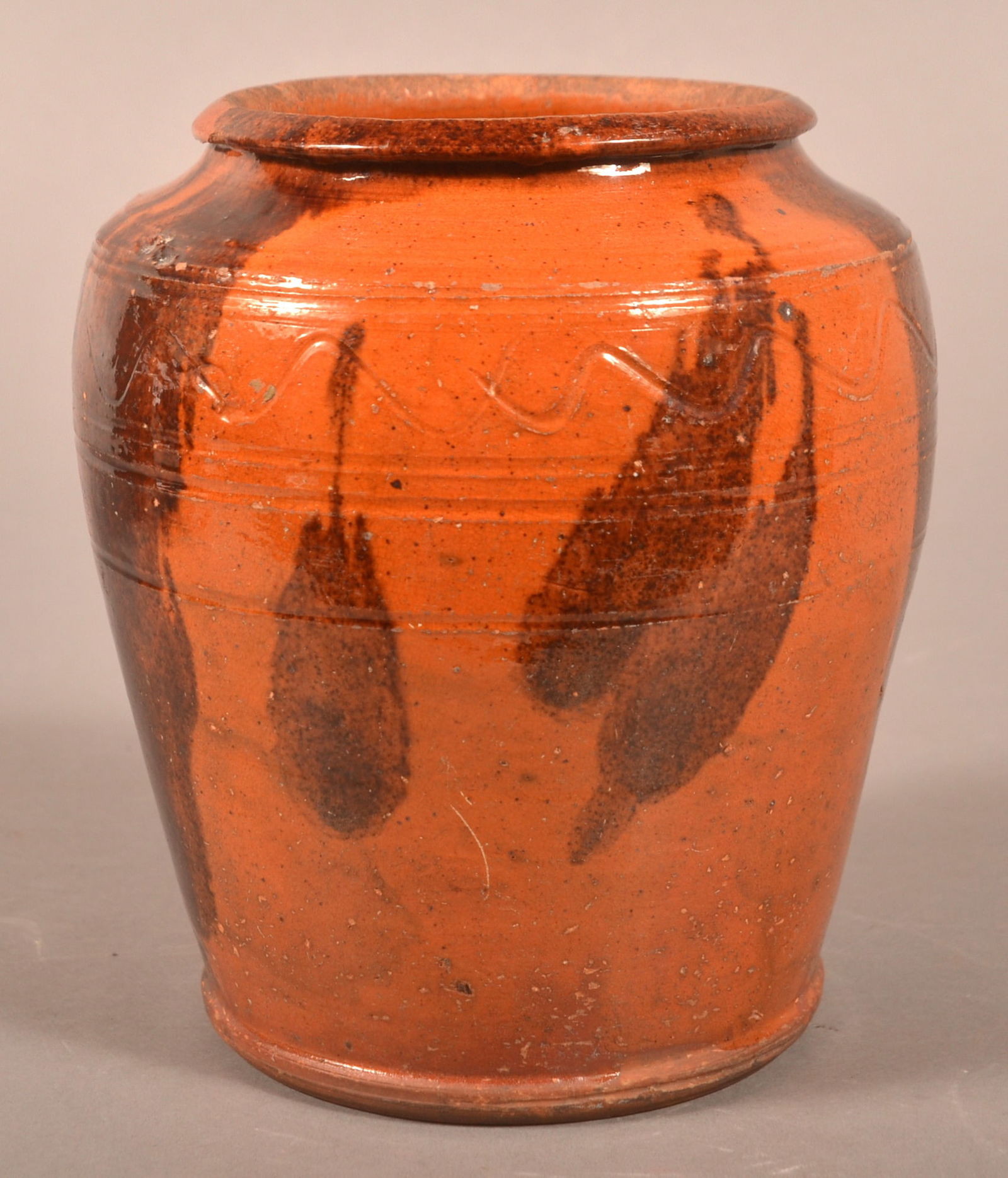 19th Century Redware Bulbous Storage Jar.: 19th Century Redware Bulbous Storage Jar. With brushed manganese on orange ground and incised band decoration. 6-1/2"h.