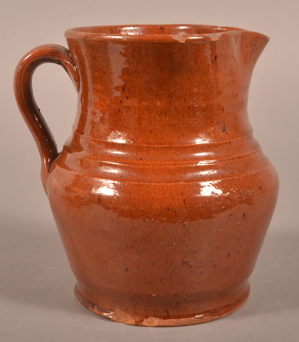 Pennsylvania Glazed Redware Milk Pitcher.: Pennsylvania Glazed Redware Milk Pitcher. Pinched spout, applied loop handle, and molded shoulder and base. 7"h.