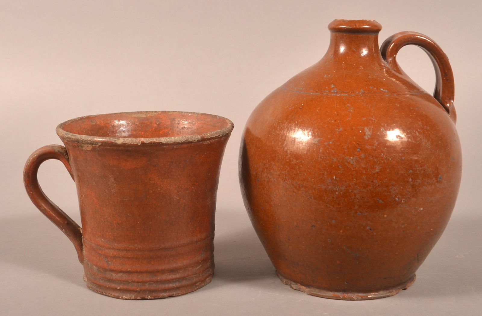 Two Pcs. of 19th Century Glazed Redware Pottery.: Two Pieces of 19th Century Glazed Redware Pottery. Bulbous-form jug and flared rim mug. 5"h. and 8-1/4"h.