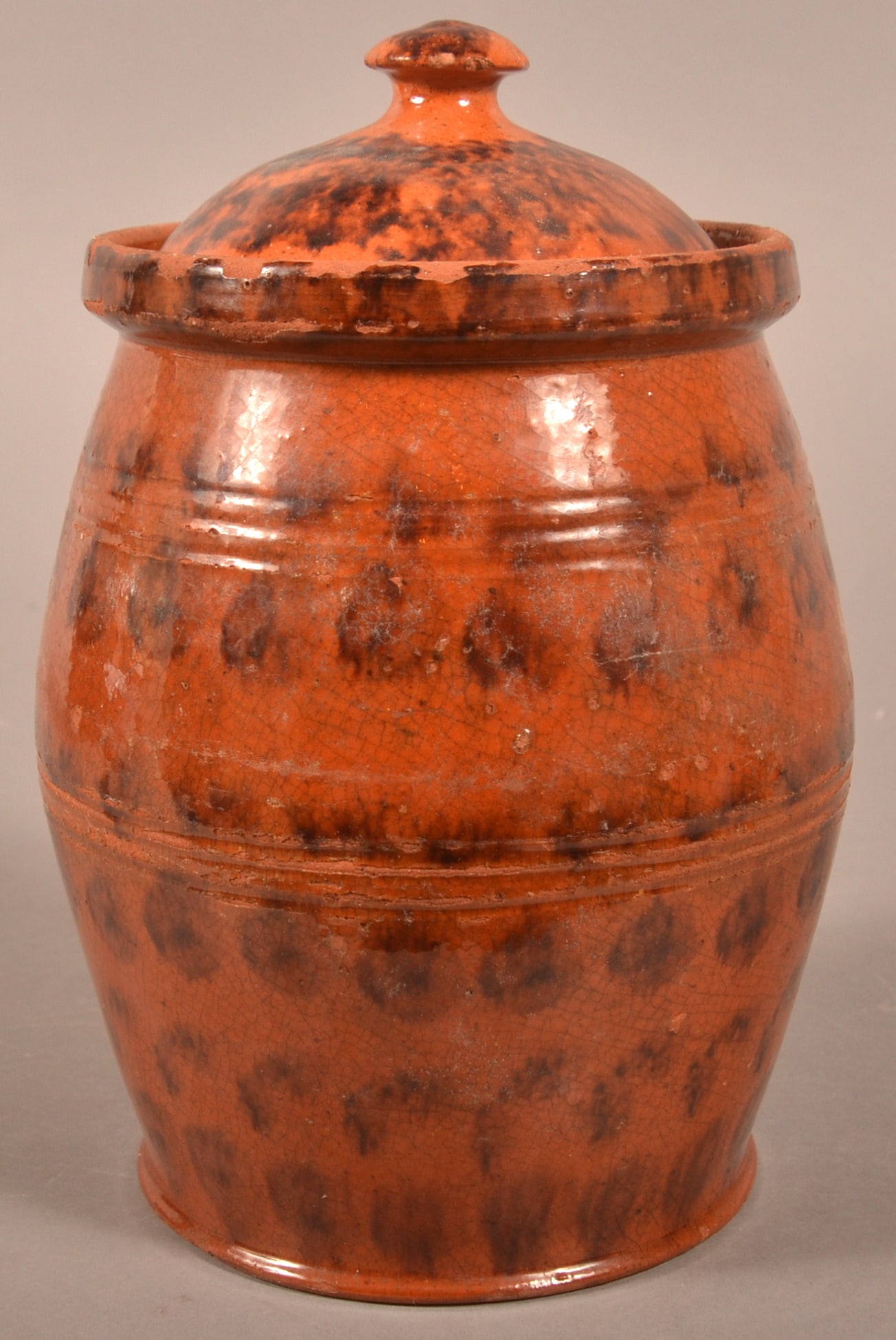Pennsylvania 19th Century Redware Covered Jar.: Pennsylvania 19th Century Redware Covered Jar. Sponge and dot manganese glaze with original dome lid, and bulbous body with tooled bands. 8-3/4"h. Provenance: Purchased at a public sale in Dillsburg,