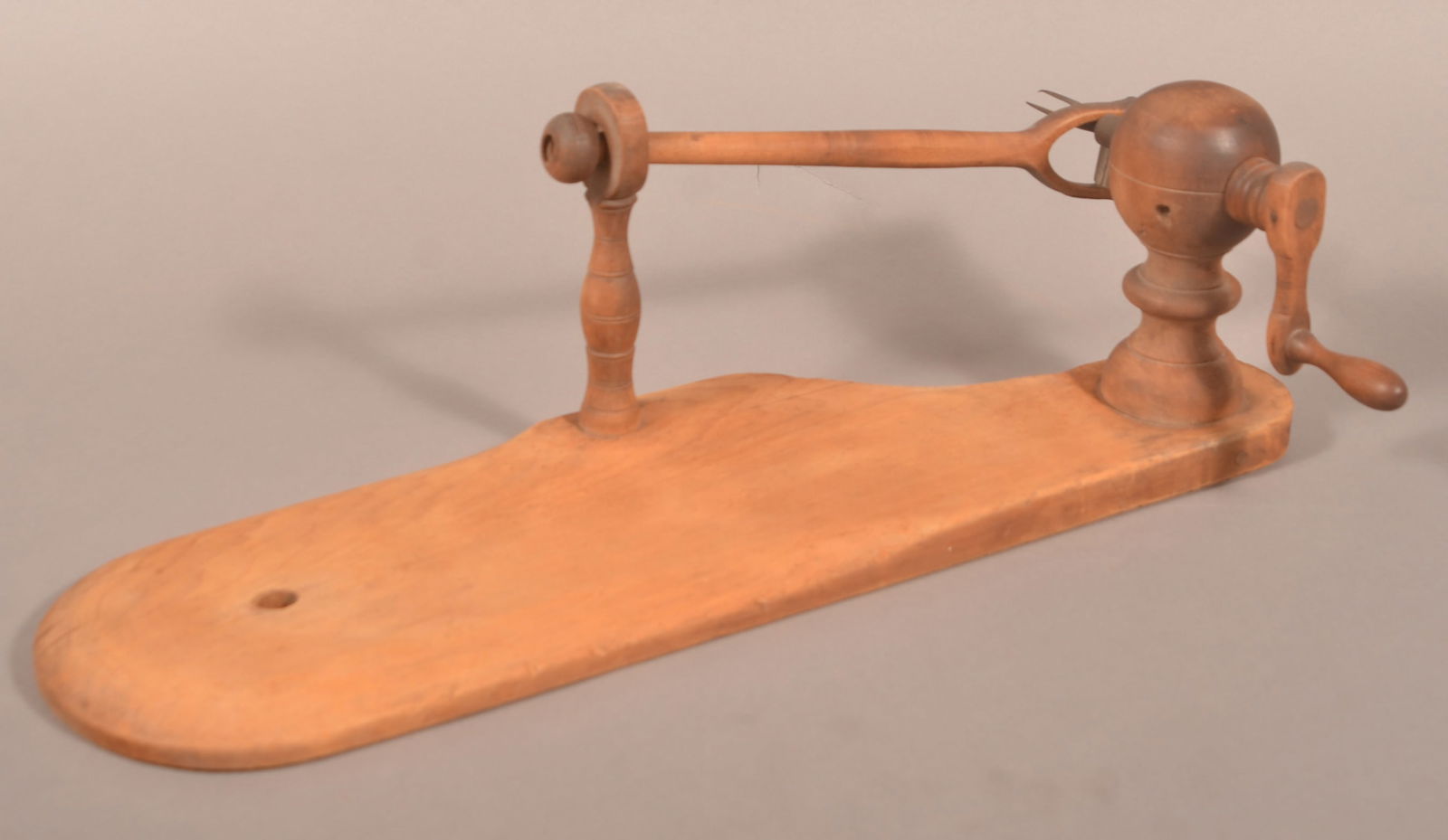 Pennsylvania 19th Century Wooden Apple Peeler.: Pennsylvania 19th Century Wooden Apple Peeler. Crank action mounted on a bed post finial-style support with shaped plank base. 23-1/2"l. overall.