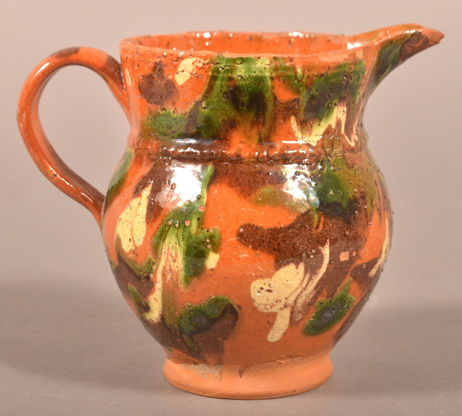 Shenandoah Valley Redware Cream Pitcher.: Shenandoah Valley Redware Cream Pitcher. Attributed to S. Bell & Sons or J. Eberly & Co., Strasburg, VA, late 19th century. Bulbous form with raised spout, ribbed loop handle, raised coggle-wheel shou