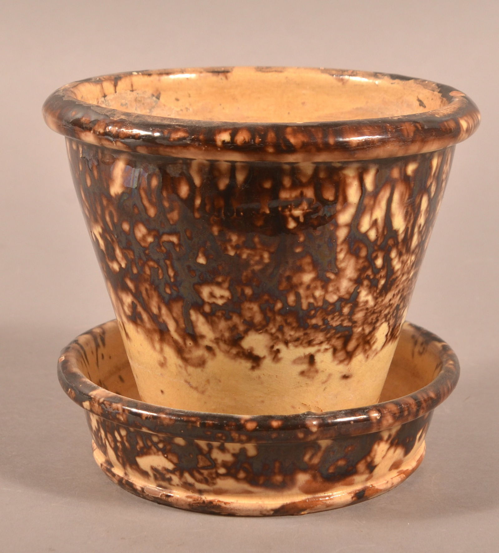 John Bell Mottled Glaze Redware Flowerpot.: John Bell Mottled Glaze Redware Flowerpot. Brown sponge mottling on yellow glazed ground and rounded rim with attached saucer base. 5-3/4"h. x 6" diam.