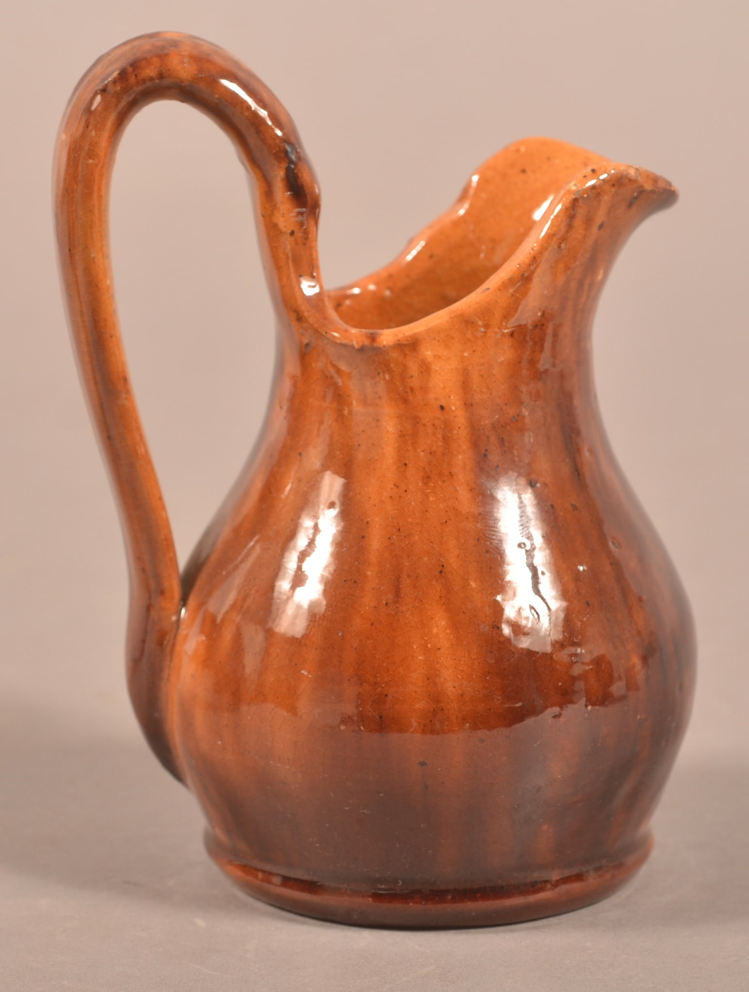 John Bell Mottled Glaze Redware Cream Jug.: John Bell Mottled Glaze Redware Cream Jug. Bulbous body with high arch loop handle. 5"h.