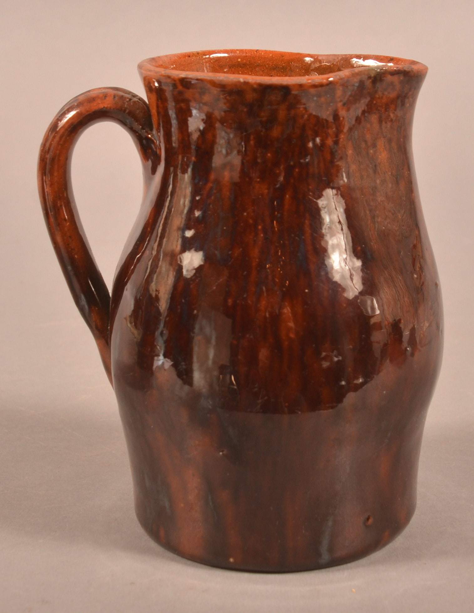 John Bell Mottled Glaze Redware Pitcher.: John Bell Mottled Glaze Redware Pitcher. Pinched spout, bulbous body and applied ribbed loop handle. 5-3/8"h.