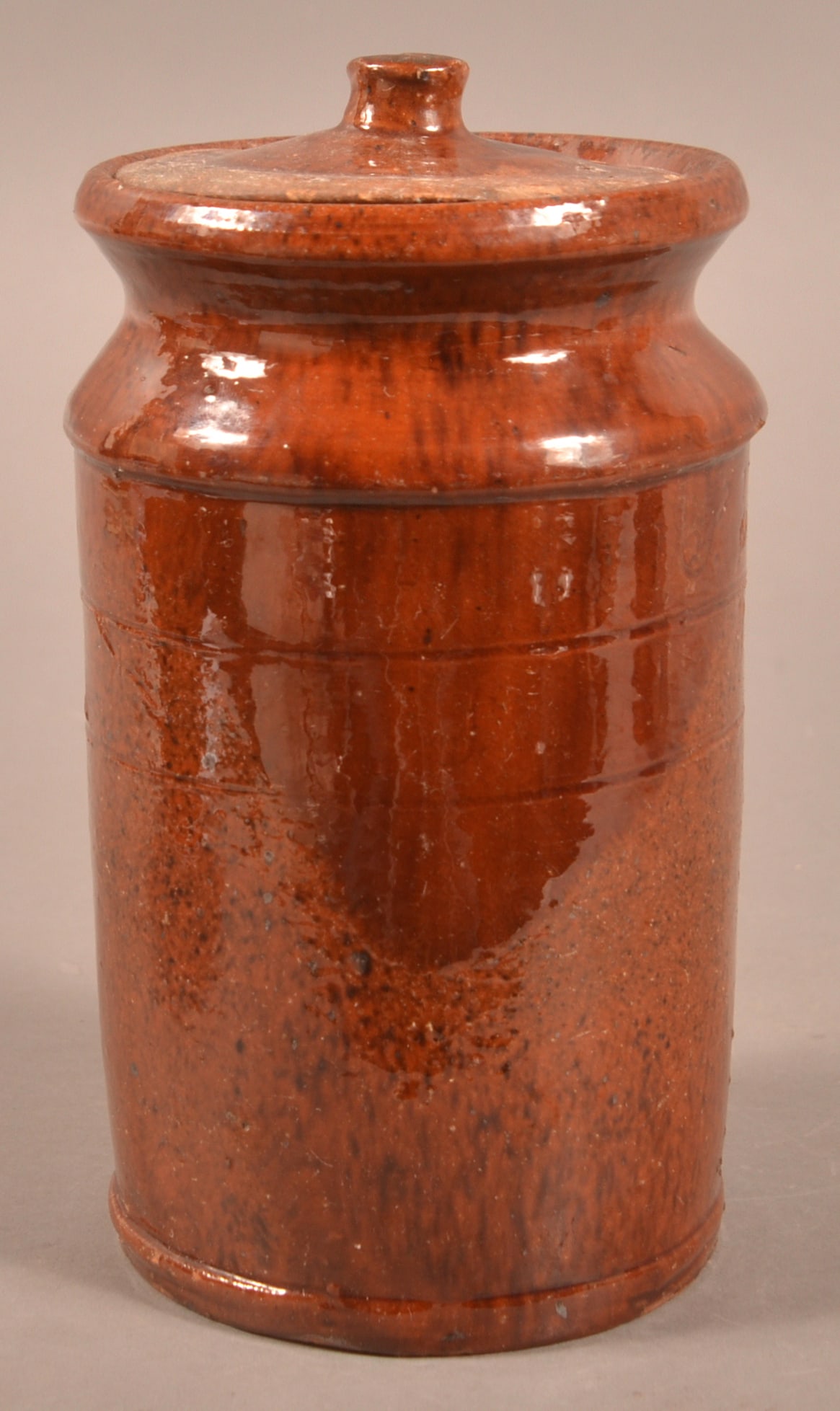 Mottled Glaze Redware Jar Incised "S.K.S.H.".: Mottled Glaze Redware Jar Incised "S.K.S.H.". Flared rim with raised shoulder, tooled cylindrical body with molded base. Accompanied with a fitted lid. 7"h.