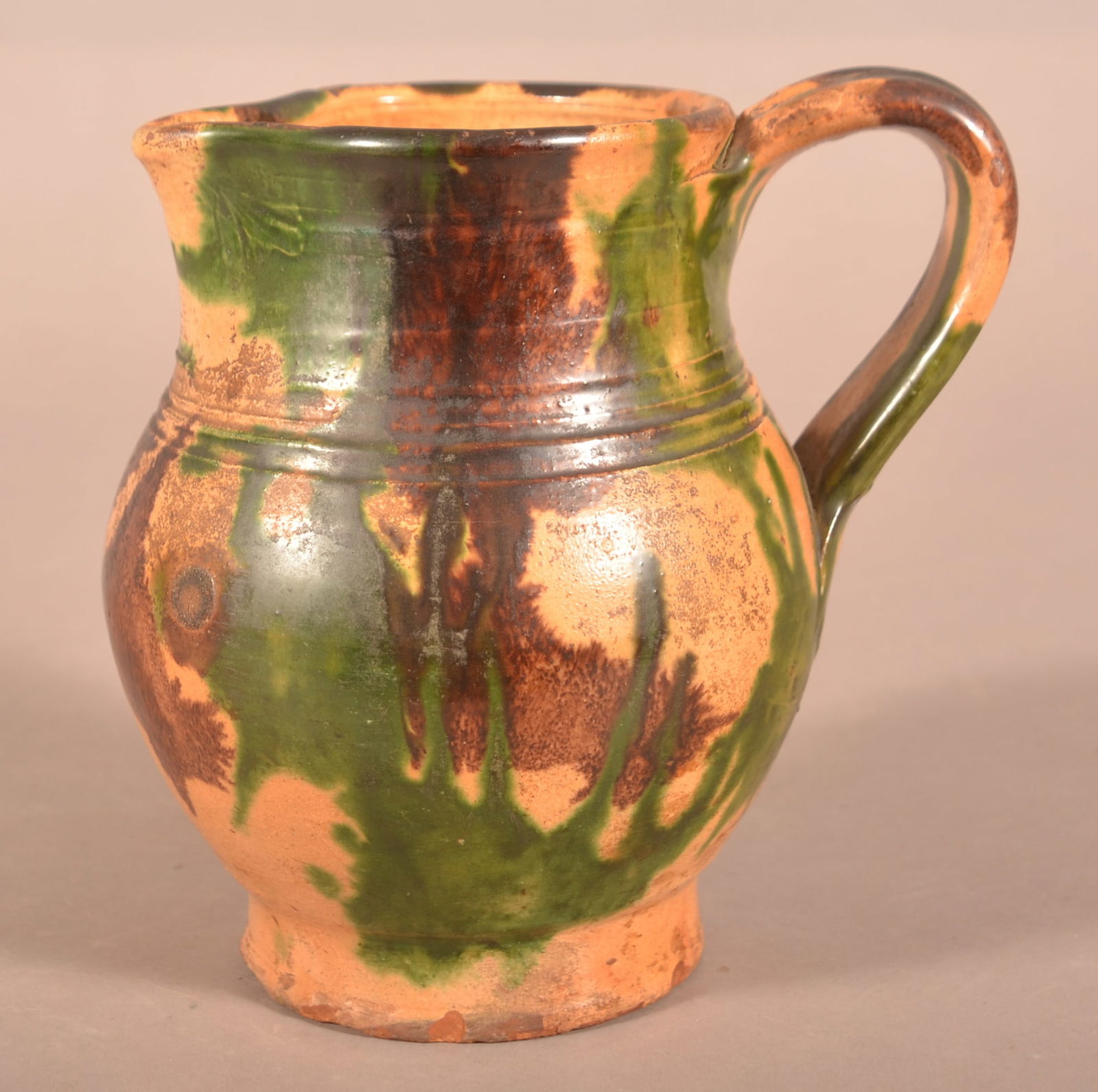 Shenandoah Valley Multi-Glazed Redware Pitcher.: Shenandoah Valley Multi-Glazed Redware Milk Pitcher. Attributed to S. Bell & Sons or J. Eberly & Co., Strasburg, VA, circa 1890. Ovoid pitcher with flared base, tooled shoulder, and flared collar with