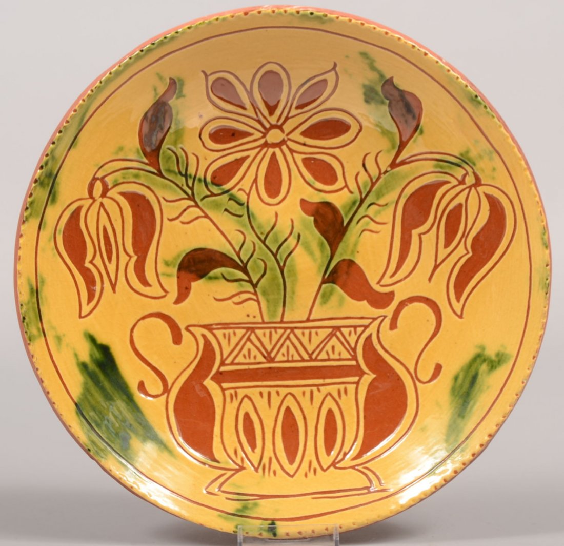 Lester Breininger Slip Decorated Redware Dish. Face of : Lester Breininger Slip Decorated Redware Dish. Face of dish is covered with yellow slip with green brush strokes and incised decoration of a fancy urn with three tulips. Coggle rim. Back of dish lists