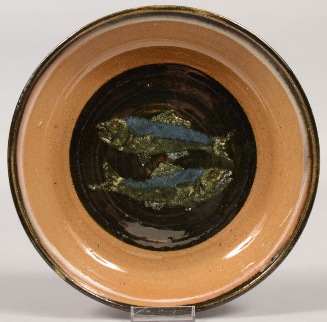 Left Handed Russell Henry Stoneware Dish. Black and whi: Left Handed Russell Henry Stoneware Dish. Black and white rim slip surrounds a center of two opposing fish on a circular black ground. Back of dish shows: " Left Handed Russell Henry who fishes in Hay