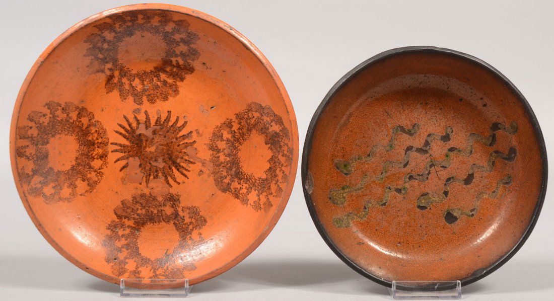 Two Slip Decorated Redware Dishes. One with five wiggle: Two Slip Decorated Redware Dishes. One with five wiggle slip lines and a smooth rim. Other has smooth rim with stamped slip designs. 7 1/4" and 8 1/4" dia. Condition: Good with use wear.